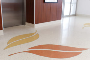 white terrazzo floor and base with decorative yellow and orange terrazzo leaves