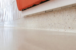 orange bench on top of white terrazzo cove base