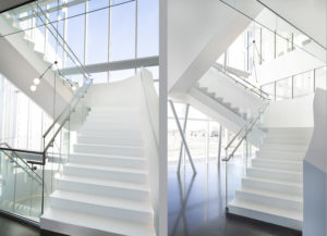 white terrazzo staircase with white railing and polished concrete floor