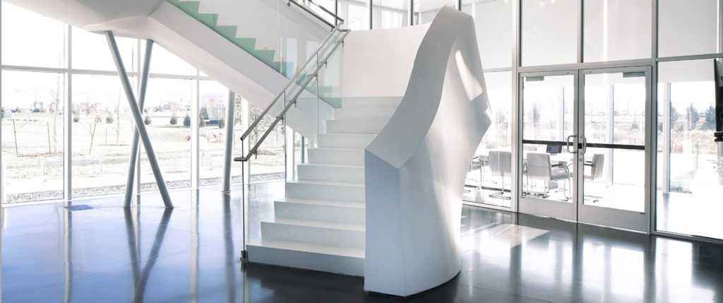white terrazzo staircase with white railing and polished concrete floor
