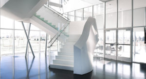 white terrazzo stair treads with a white railing and polished concrete floor