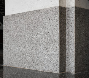 gray terrazzo column with black terrazzo floor and white walls